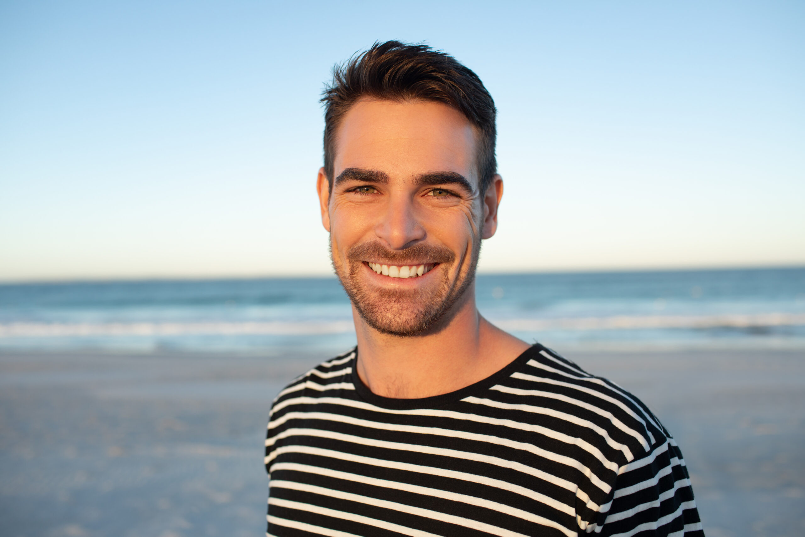 Portrait of happy man standing on the beach