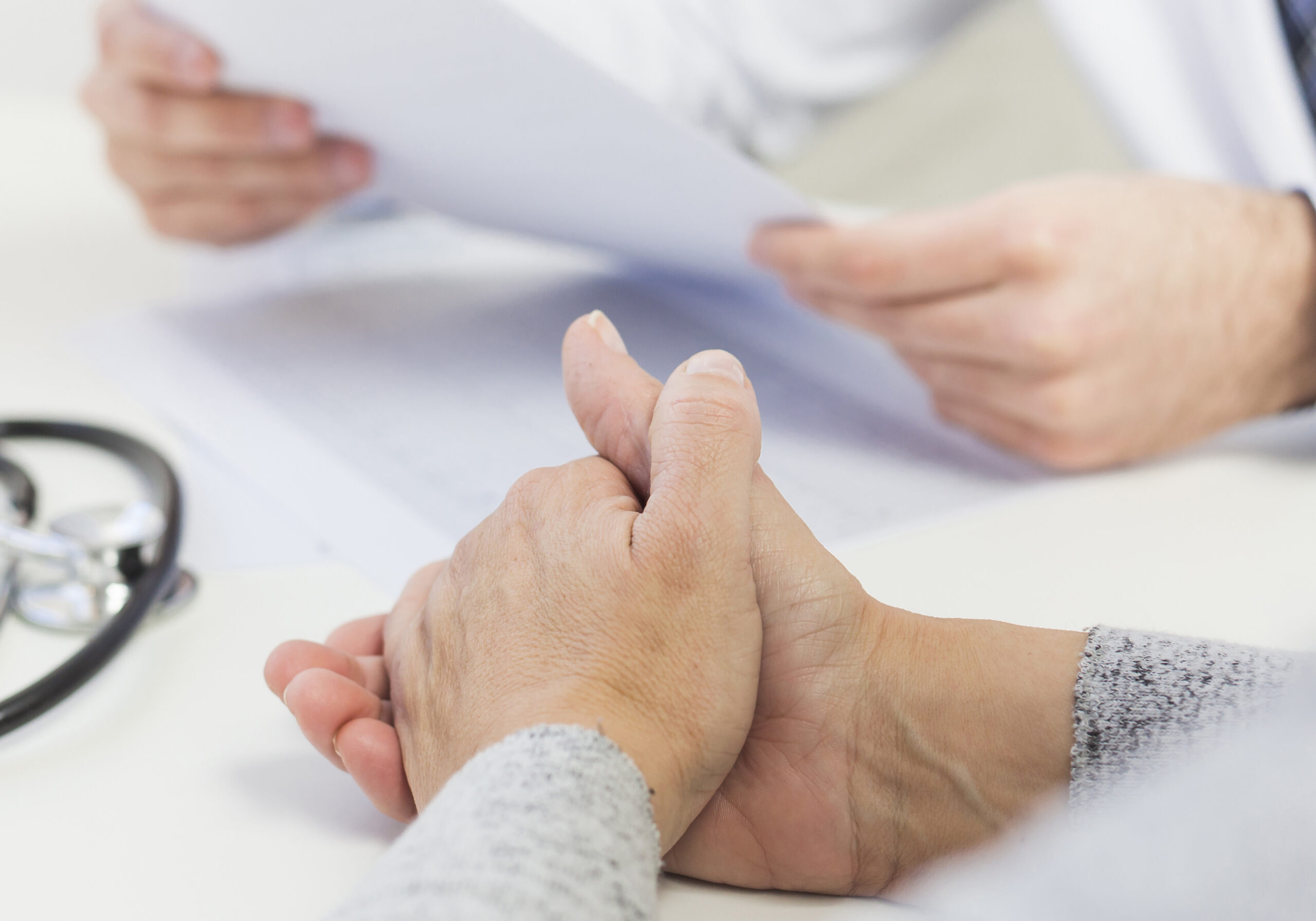 close-up-female-patient-sitting-near-doctor-holding-medical-report